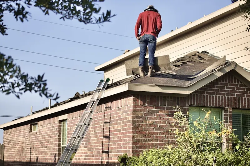 Professional roofer working on a residential roof in Volney